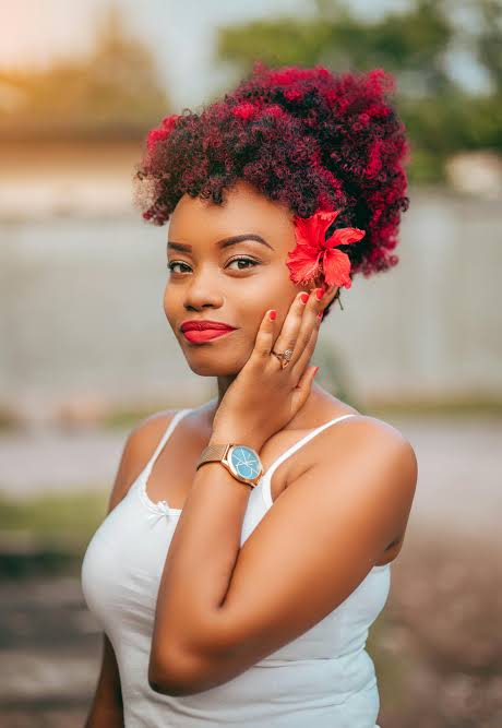 Woman with red curly updo hairstyle and hibiscus flower accessory