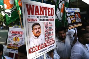 Protesters hold placards of Education Minister