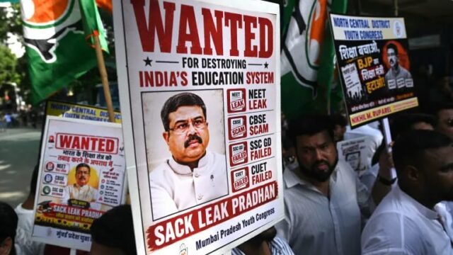 Protesters hold placards of Education Minister