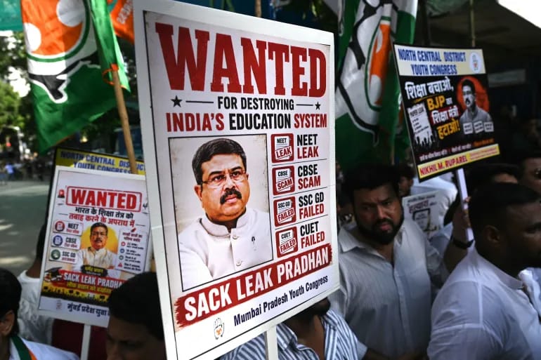 Protesters hold placards of Education Minister