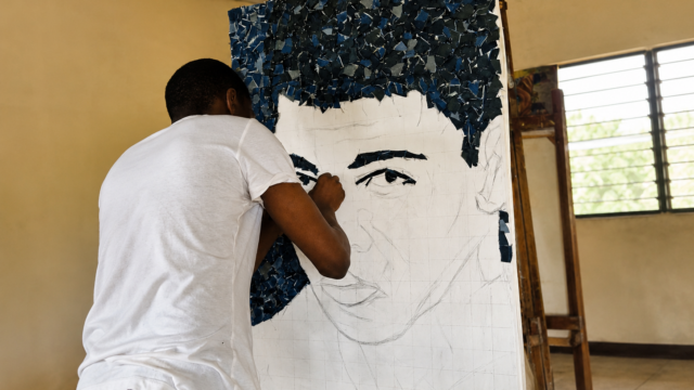 Praise Agunbiade creating a denim portrait of Muhammad Ali.