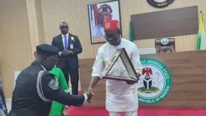 PHOTO CAPTION: Anambra State Governor, Chukwuma Soludo, presenting an award plaque to retired AIG Ikioye Orutugu