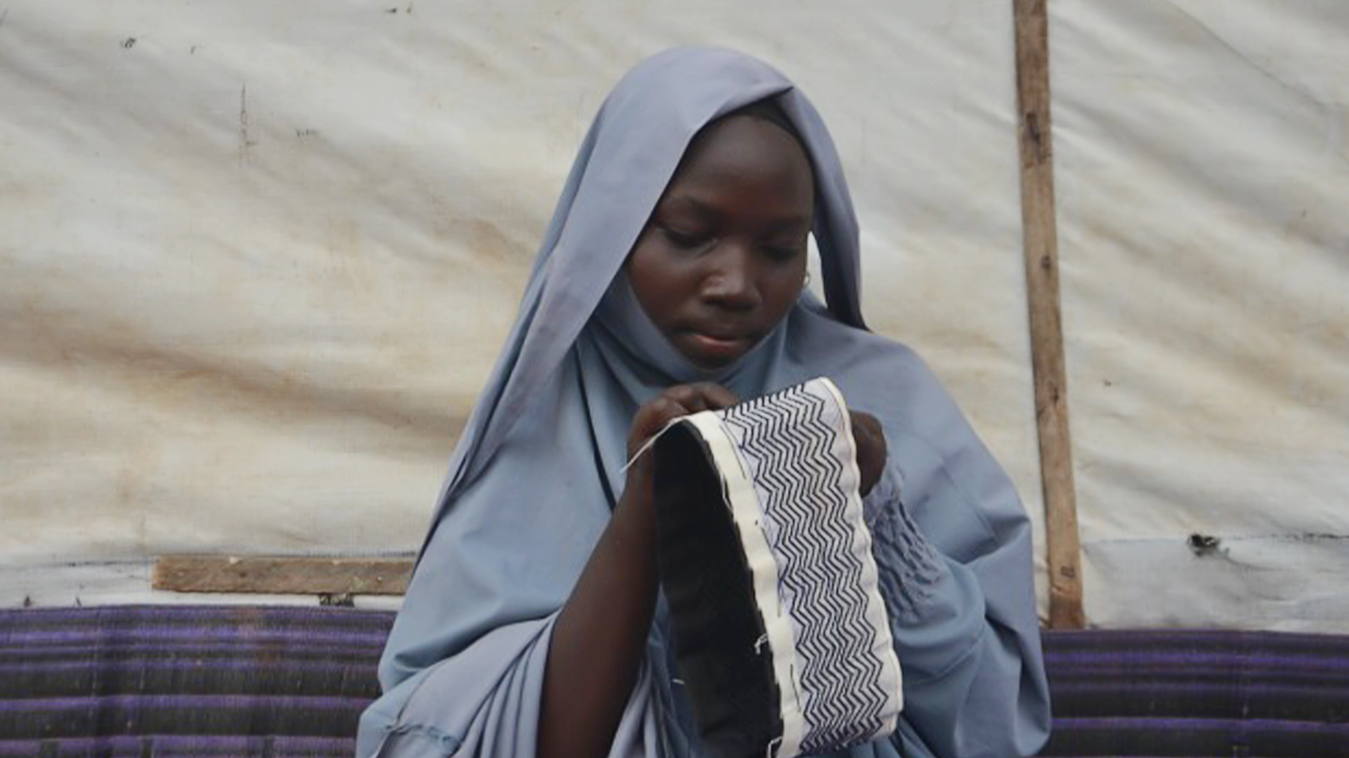 Fatimah Ali stitching a fabric.