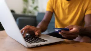 Man typing Mastercard card details onto a laptop