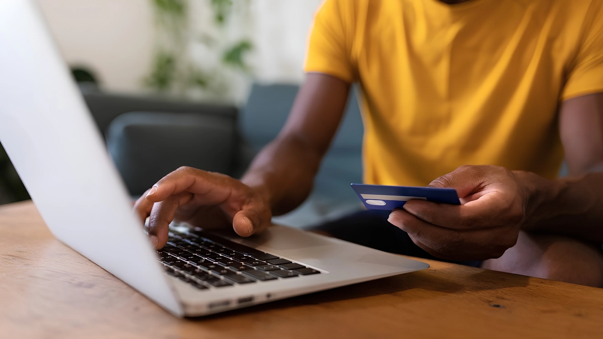 Man typing Mastercard card details onto a laptop