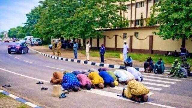 worshippers praying on the road