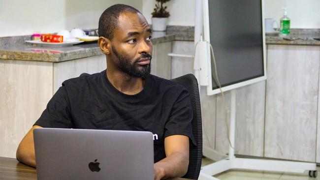 Hamid Bashir, product manager at Distinction Labs, working on his laptop at FlexiSaf’s office in Garki, Abuja, Nigeria.