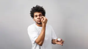 Young man apply skincare product