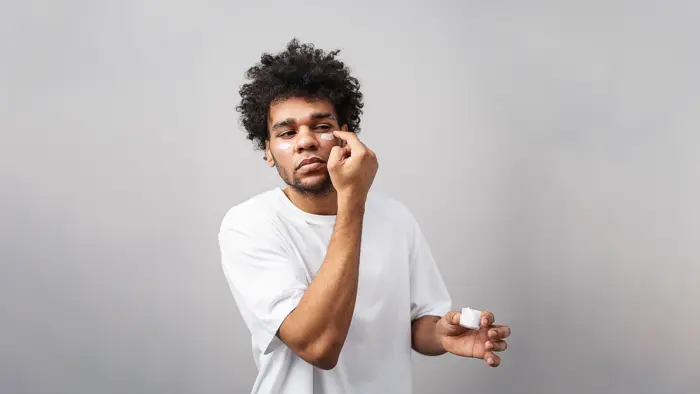 Young man apply skincare product