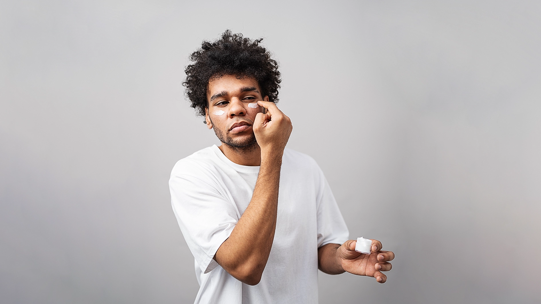 Young man apply skincare product