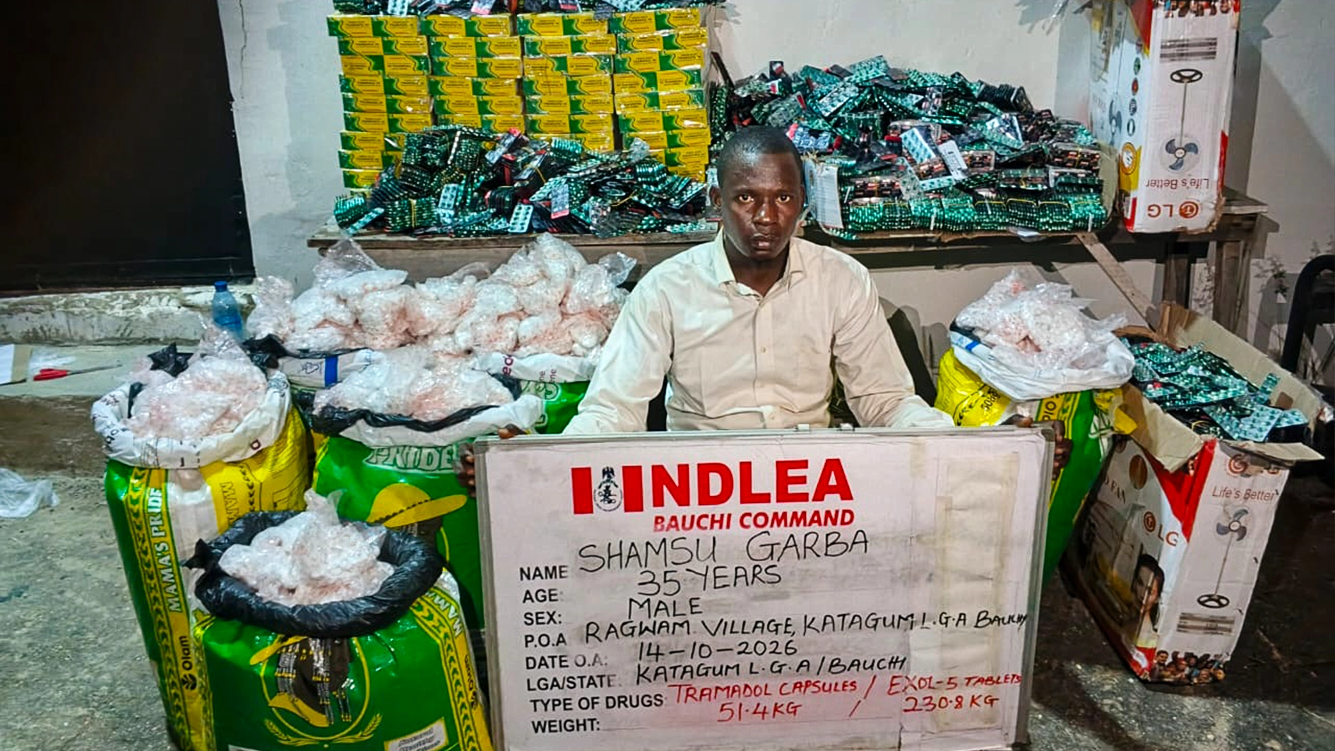 Suspect with seized illicit drugs.